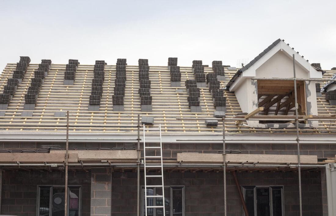 Roofing crew working from scaffolding during roof work